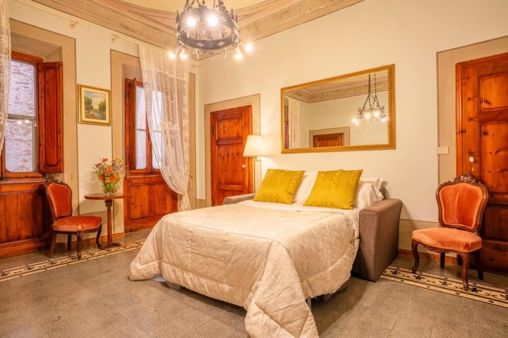 Camera elegante a Palazzo Trecci Tombesi con letto matrimoniale in lusso toscano a Montepulciano, ideale per famiglie e coppie.