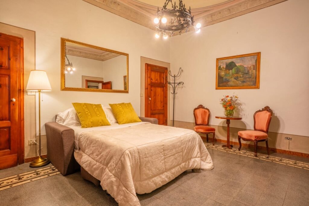 Camera lussuosa Palazzo Trecci Tombesi con letto matrimoniale elegante a Montepulciano.