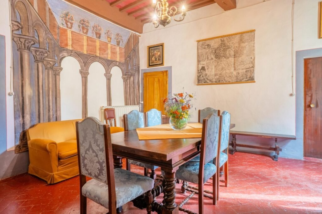Sala da pranzo elegante di Palazzo Trecci Tombesi con affreschi storici e arredamento classico a Montepulciano.
