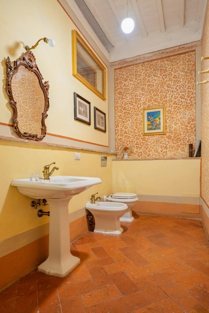 Bagno elegante in villa di lusso a Montepulciano, con sanitari raffinati e decorazioni classiche, ideale per relax toscano.