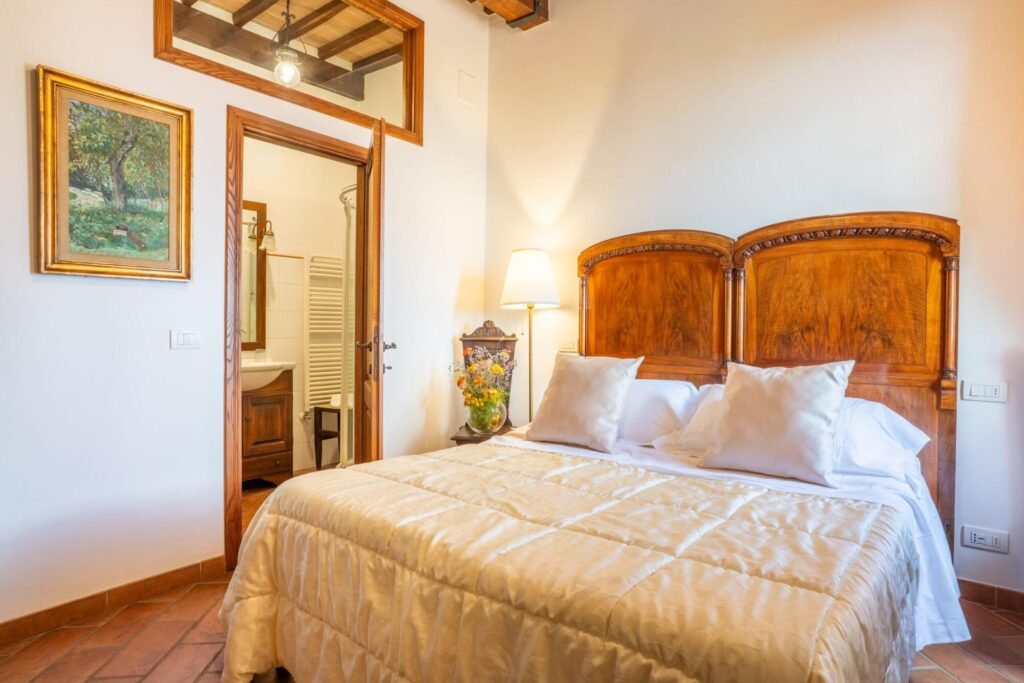 Camera da letto lussuosa con arredi classici a Dimore Pulcino, Montepulciano. Comfort elegante in Toscana.