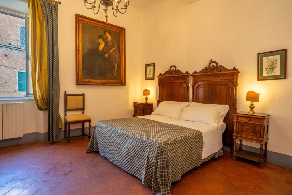 Camera da letto elegante con arredi antichi in un appartamento di lusso a Palazzo Trecci Tombesi, Montepulciano.
