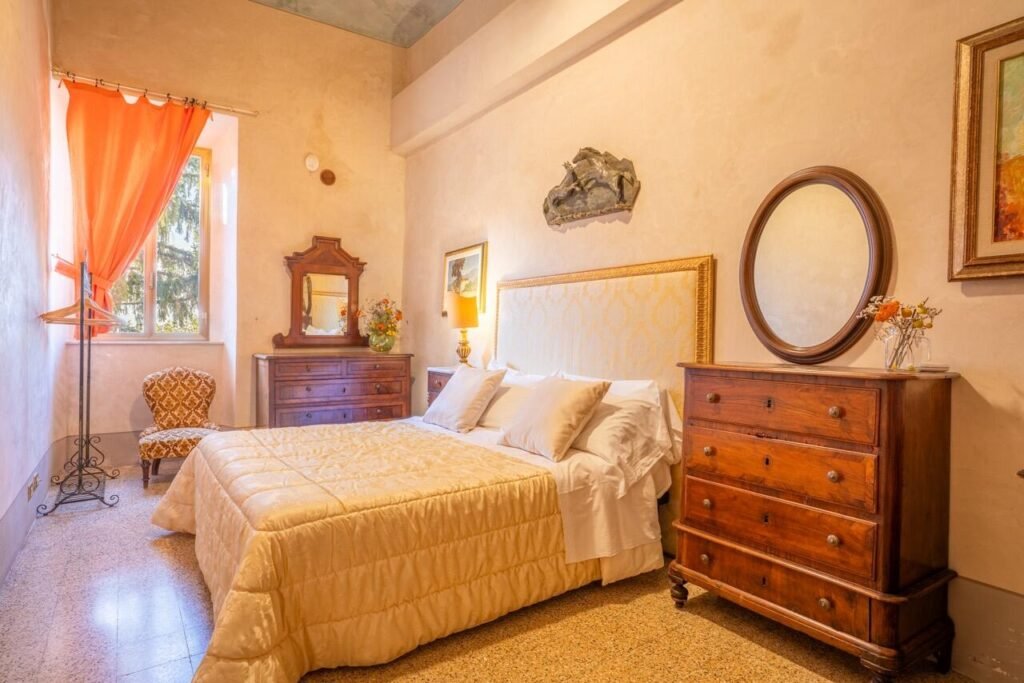 Camera da letto di lusso a Palazzo Danesi, Montepulciano, con arredo elegante e dettagli toscani.