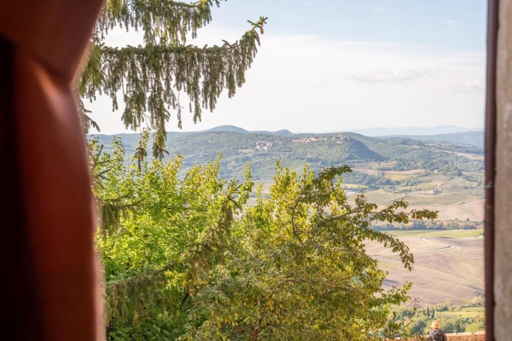 Vista panoramica dalla finestra di Palazzo Danesi, Dimore Pulcino, Montepulciano, colline toscane in lontananza.