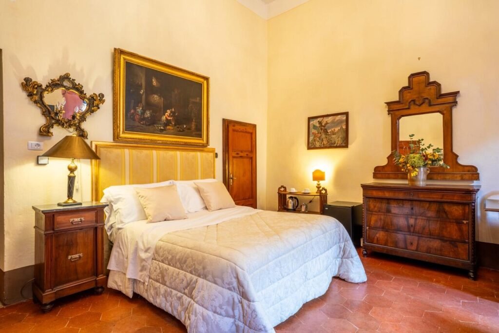 Camera lussuosa a Palazzo Danesi con letto elegante e arredi d'epoca, Montepulciano.